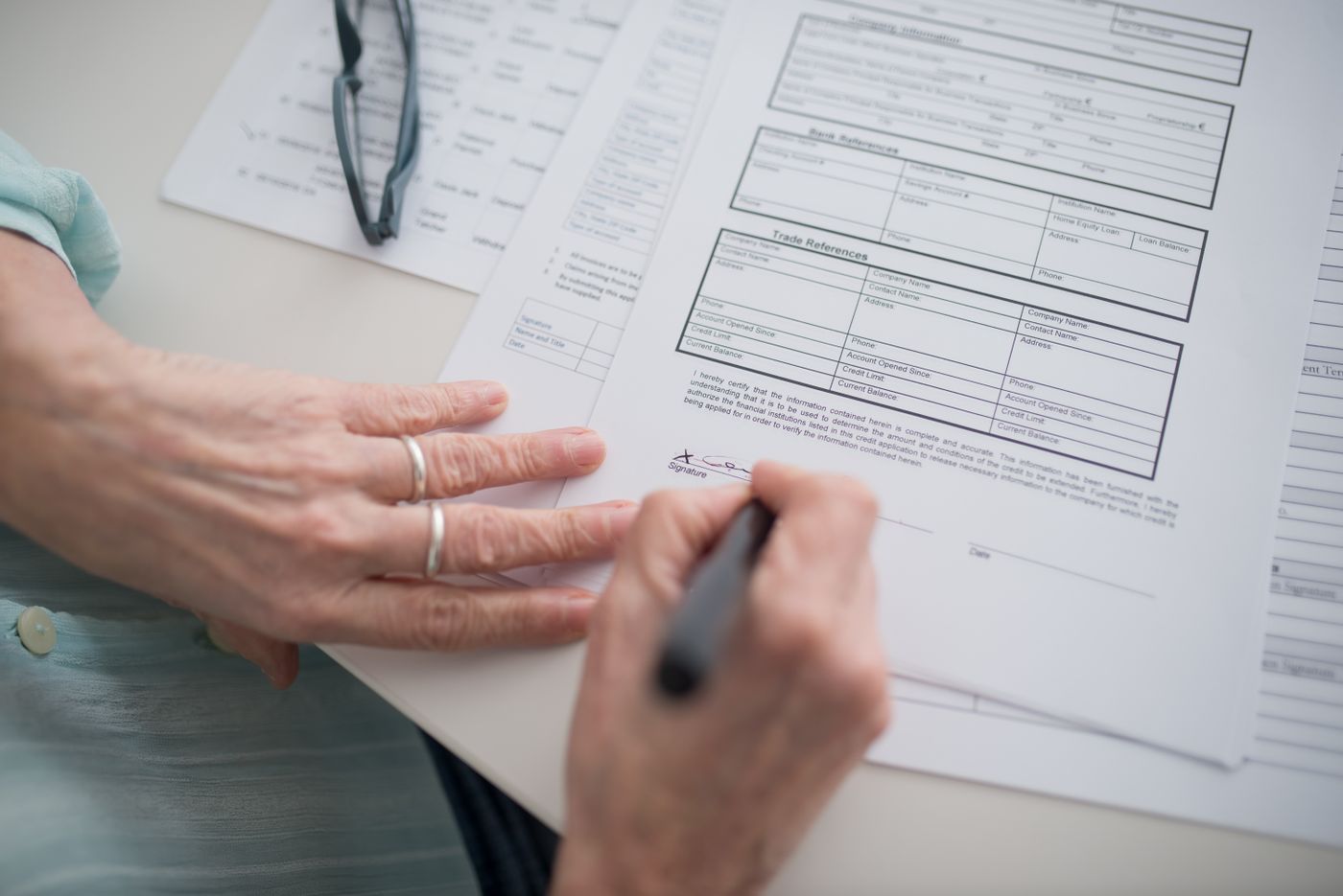 A person signing a printed form.
