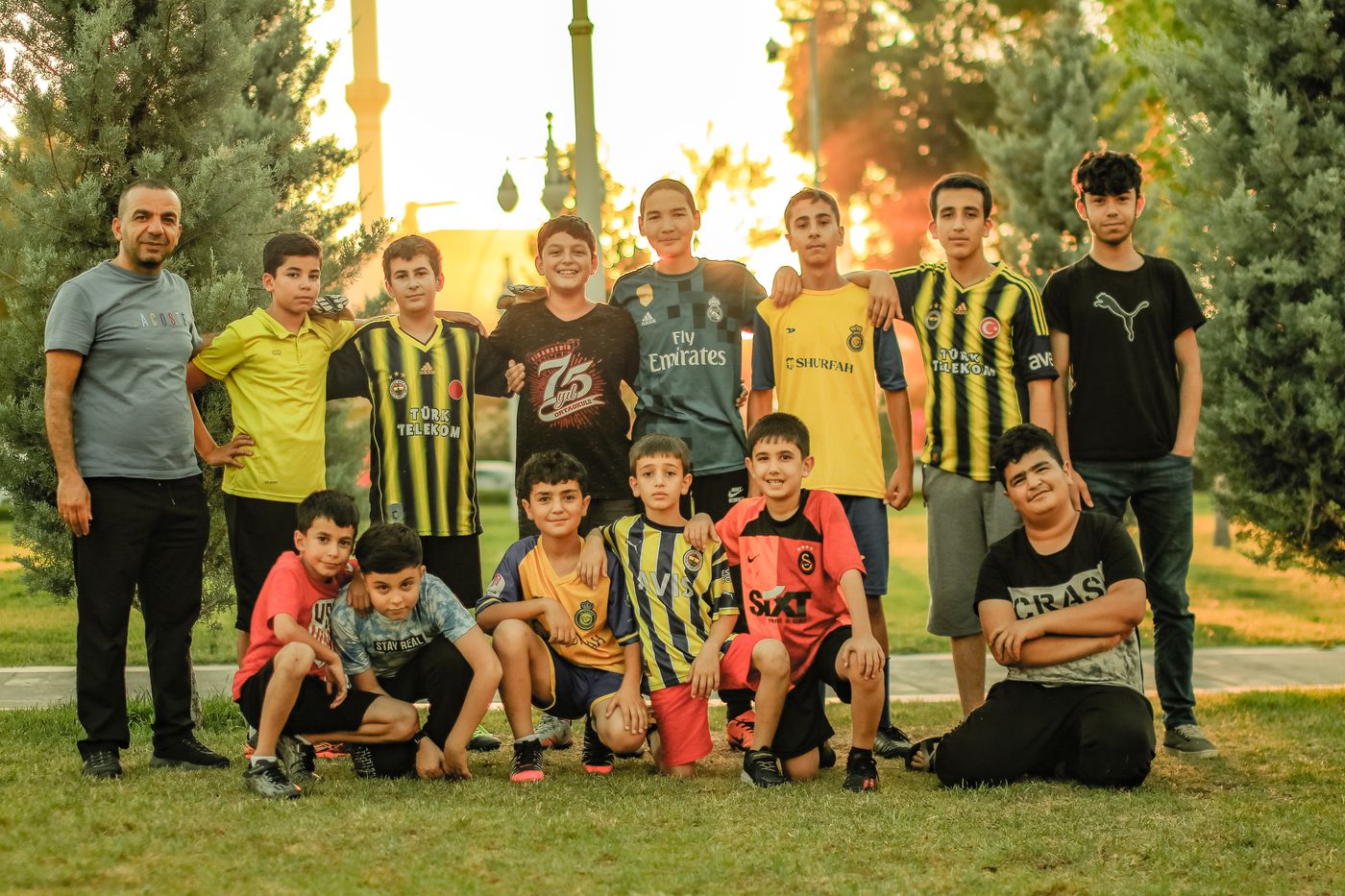 A youth soccer team posing with a coach on the grass.